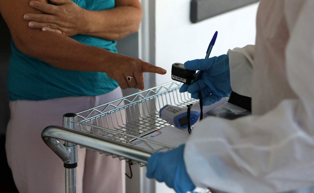 Doctor checks a Central American migrant at the so-called 'filter hotel', rented by the World Organization for Peace (WOFP) and the United Nations International Organization for Migration to host migrants top be quarantined amid the COVID-19 pandemic