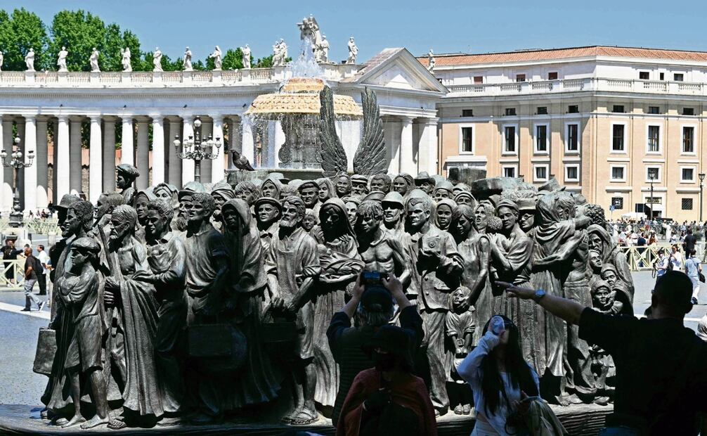 Visitantes junto a la escultura de bronce Ángeles Inadvertidos, de Timothy Schmalz, en la Plaza de San Pedro del Vaticano. Foto: Andreas Solaro/ AFP