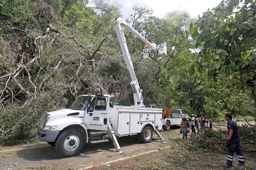 Empleados de la Comisión Federal de Electricidad en Casimiro, Jalisco, trabajan para restablecer el servicio en la región (EDUARDO VERDUGO. AP)