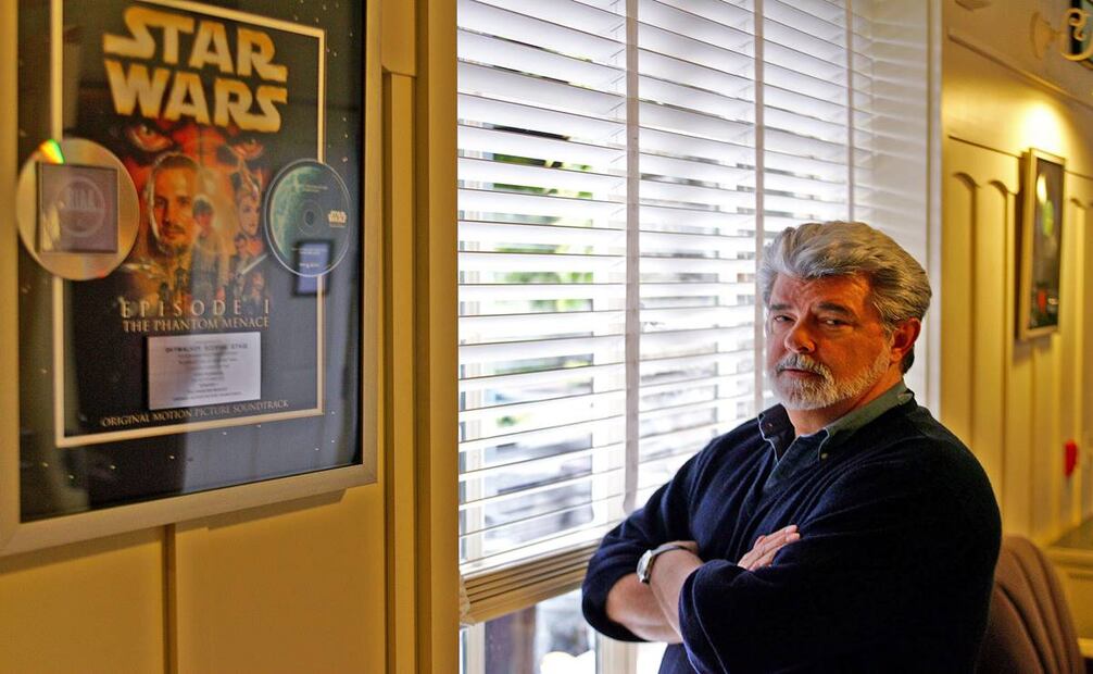 El director de las primeras seis películas de Star Wars, George Lucas, posa frente a un poster de "La amenaza fantasma" en su Rancho Skywalker de San Rafael, California. Foto: Eric Risberg/AP.