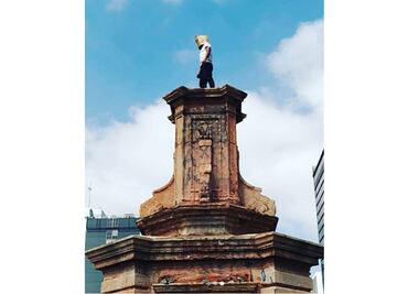 Artista hace performance en el pedestal del Monumento a Colón en Reforma como protesta