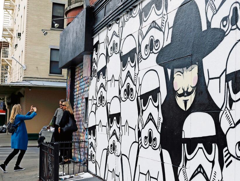 La gente toma fotografías junto a un mural del artista callejero neoyorquino JerkFace . El mural representa a Guy Fawkes y a Stormtroopers. Foto: EFE
