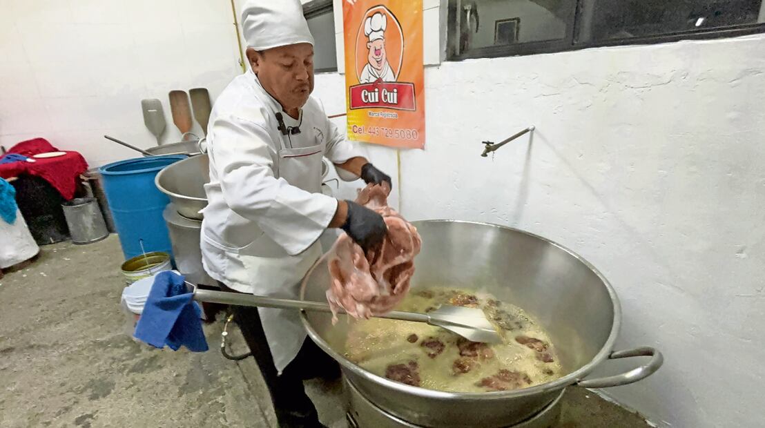 Antonio echa primero a sellar las piernas del cerdo, después avienta al cazo la espaldilla, el lomo y las costillas. Foto: Carlos Arrieta / EL UNIVERSAL