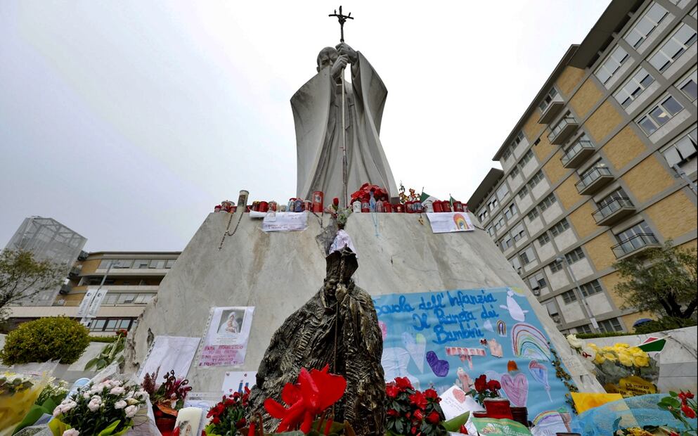 Imagen de una escultura y velas ante la estatua de Juan Pablo II en el Hospital Universitario Gemelli, donde el Papa Francisco está hospitalizado, en Roma, el 1 de marzo de 2025. Foto: EFE