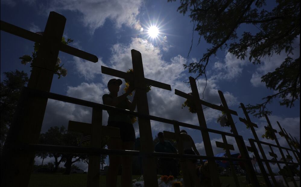 Una persona coloca flores en un monumento improvisado para las víctimas de las inundaciones, instalado a orillas del río Guadalupe, en Kerrville, Texas. el sábado 12 de julio de 2025. Foto: AP