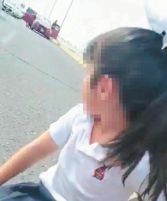 “Papá, ¿ya nos podemos parar?”, pregunta inocente una menor con uniforme escolar, esperando que termine el enfrentamiento. TOMADA DE VIDEO