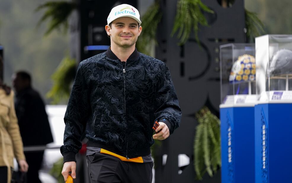 El piloto mexicano de McLaren, Pato O'Ward, camina frente a una exhibición de casos de pilotos de Fórmula Uno en el Autódromo Hermanos Rodríguez. Foto: AP