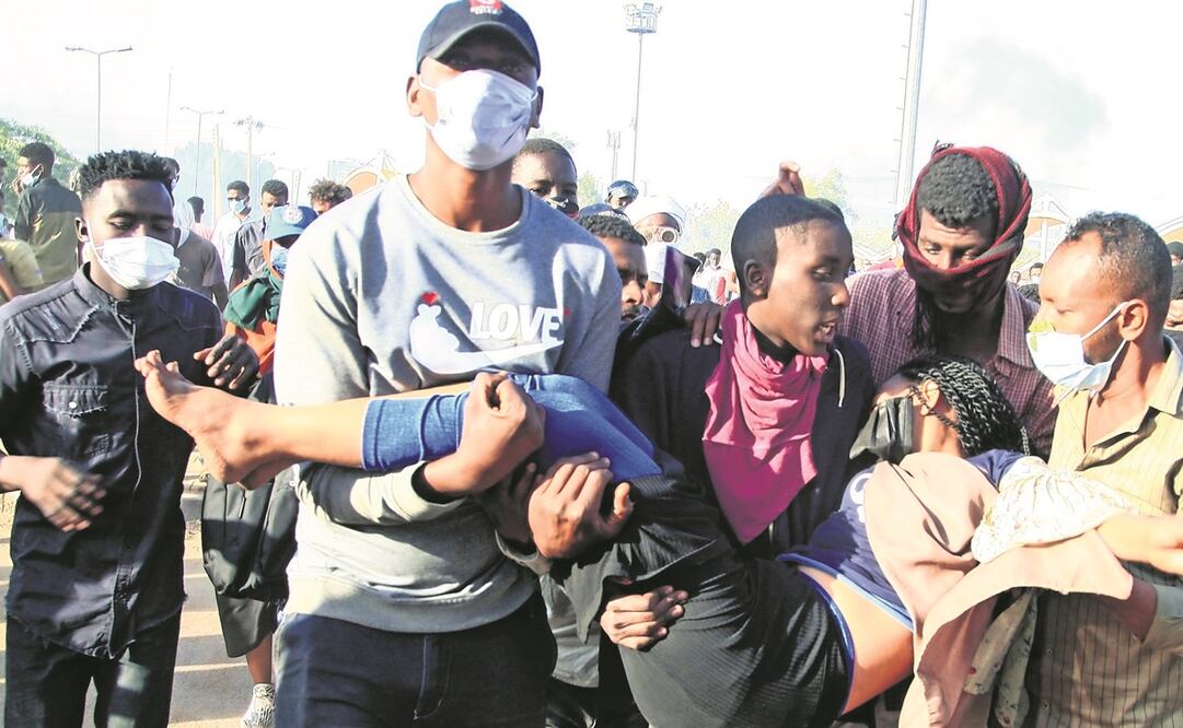 Manifestantes sudaneses cargan a una mujer herida, durante las protestas de ayer contra el golpe de Estado, en Jartum. Foto: AFP