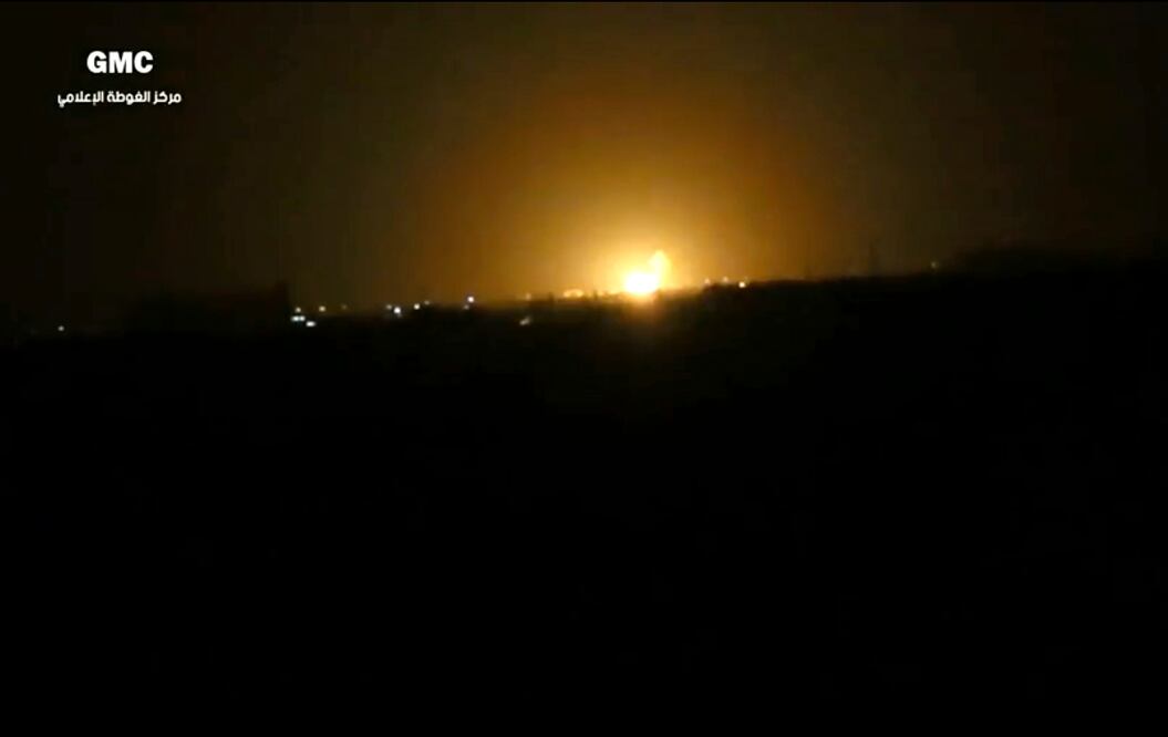 Escena extraída de un video proporcionado por el grupo activista opositor Ghouta Media Center, confirmada por su contenido y otra información de AP, muestra llamas elevándose tras una explosión cerca de un aeropuerto al oeste de Damasco (AP)