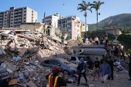 Residentes y rescatistas buscan entre los escombros de un edificio que se derrumbó durante los  terremotos en Caracas.  FOTO: ARIANA CUBILLOS. AP