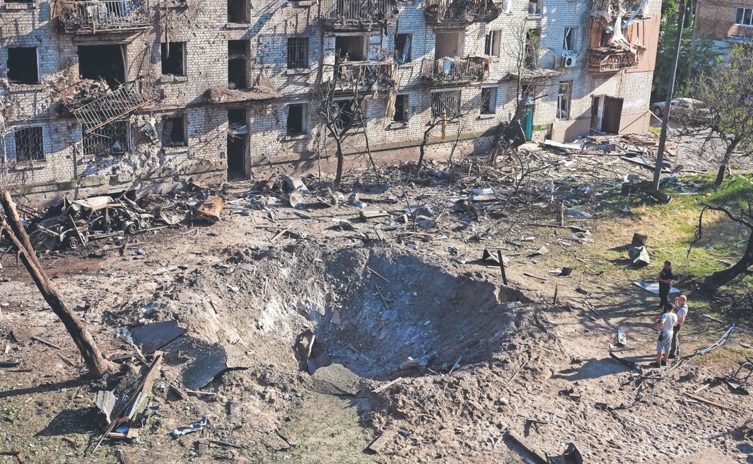 Testigos en el lugar donde impactó un misil ruso contra un edificio residencial en Kiev. Foto: Efrem Lukatsky. AP