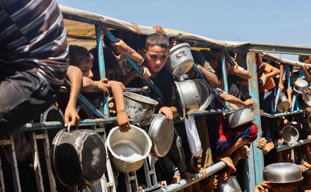 Niños palestinos esperan una comida en un comedor benéfico en el área de Mawasi de Khan Yunis, en el sur de la Franja de Gaza. Foto: AFP