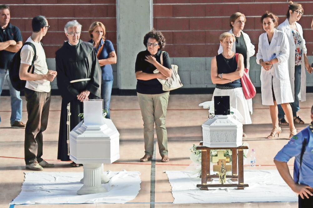 Féretros con los cuerpos de niños muertos en el terremoto fueron colocados ayer en un gimnasio en la provincia italiana de Ascoli Piceno (GREGORIO BORGIA. AP)