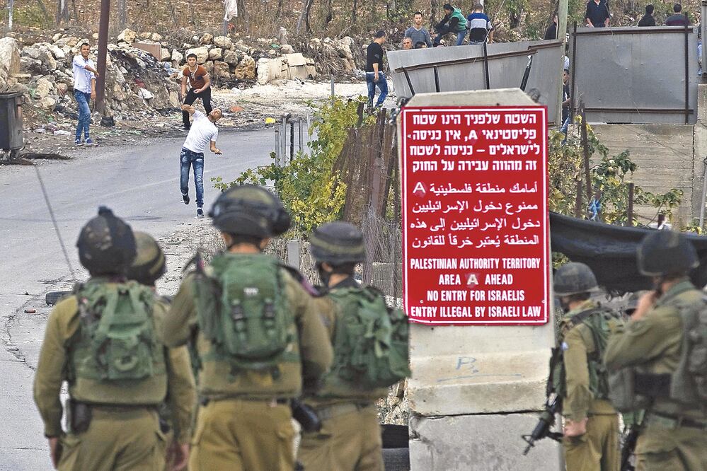Palestinos lanzan piedras a soldados israelíes en Hebrón el lunes pasado (RONEN ZVULUN)