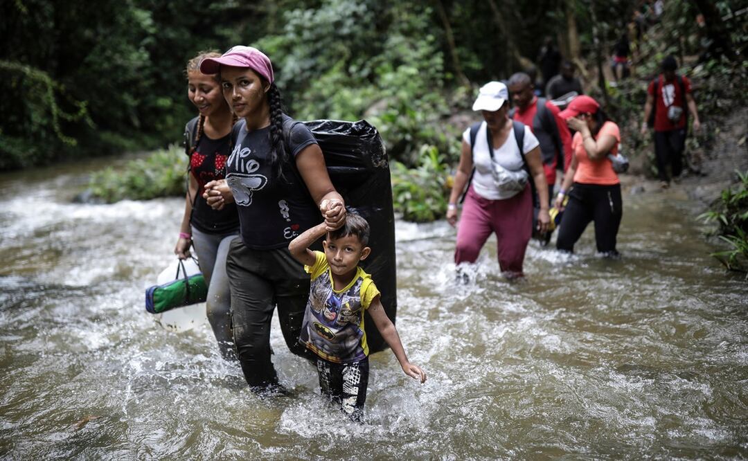 Migrantes cruzan un río mientras en el Darién, desde Colombia a Panamá, con la esperanza de llegar a Estados Unidos. Foto: AP