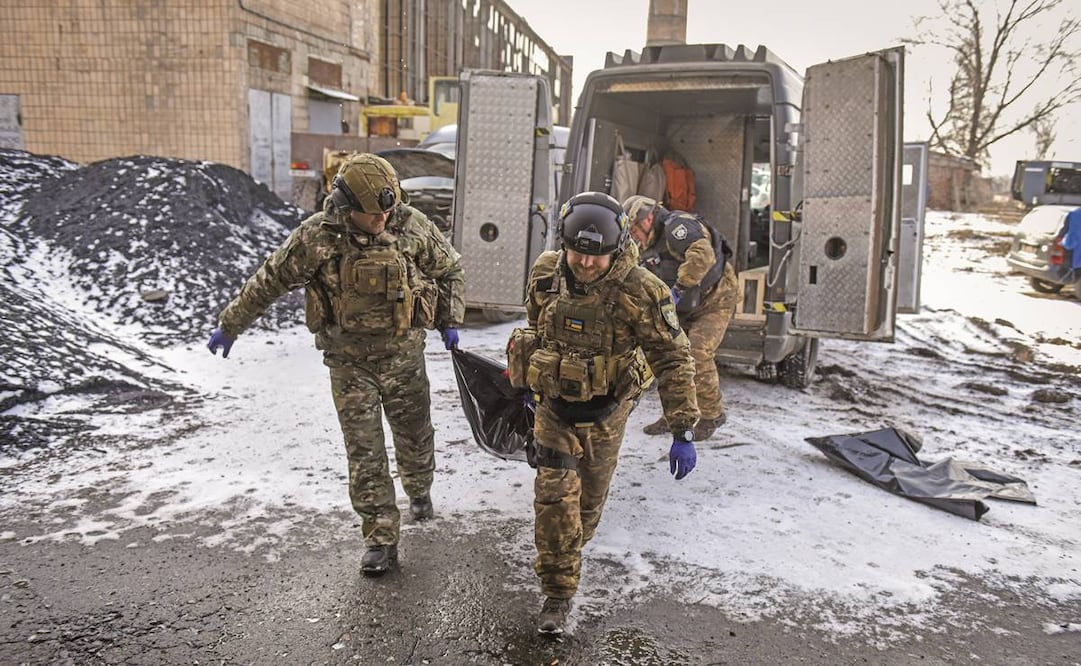 Integrantes de una unidad policiaca, con restos de una persona fallecida en un bombardeo en Bakhmut. Foto: Oleg Petrasyuk/EFE