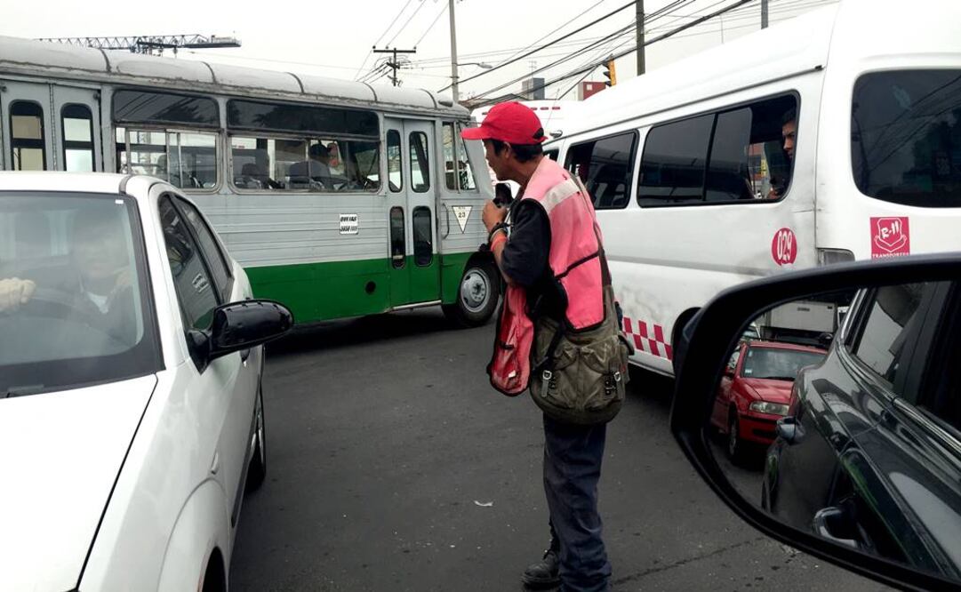 Un hombre con chaleco anaranjado intenta regular el paso de vehículos a cambio de unas monedas en la zona afectada. (Foto: Rebeca Jiménez / El Universal)