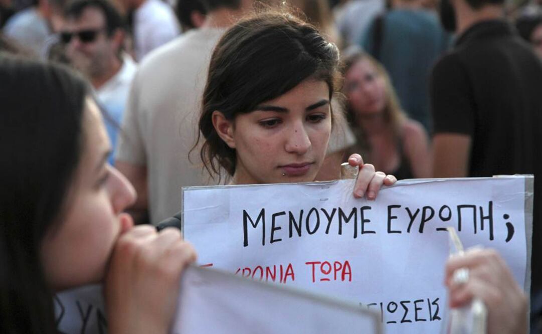 Cientos se manifestaron en Atenas contra la austeridad. En la foto, una joven sostiene una pancarta que dice: ¿Nos quedamos en el euro? Foto: Reuters