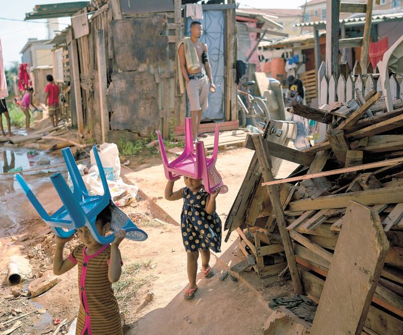 Dos niñas pasean con sillas sobre sus cabezas, en Río de Janeiro. Brasil ocupa el cuarto lugar en matrimonios infantiles, señala el UNFPA. LEO CORREA. AFP