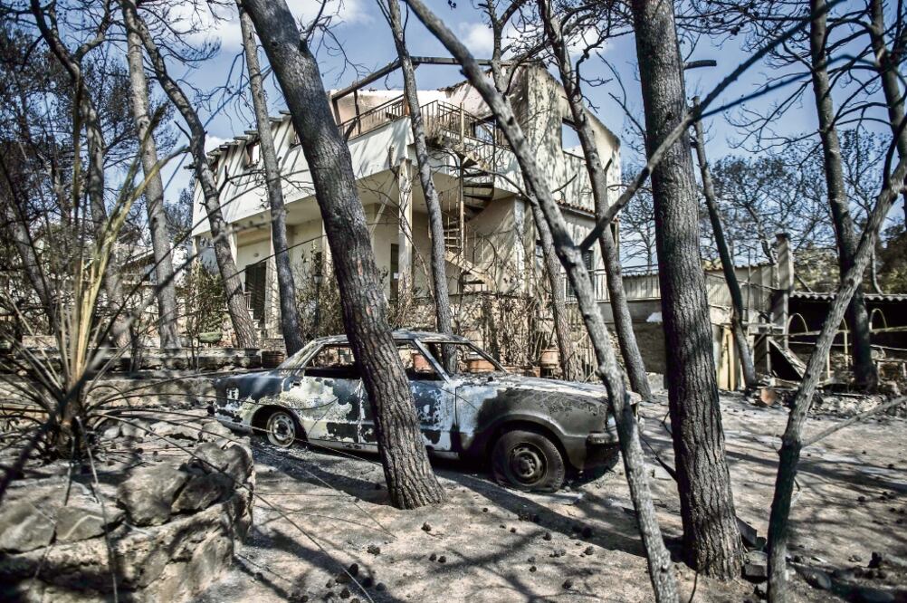 Vehículos y casas quemados, es lo que quedó en la localidad de Mati, cerca de Atenas, devastada por incendios que han dejado 81 muertos (ANGELOS TZORTZINIS. AFP)
